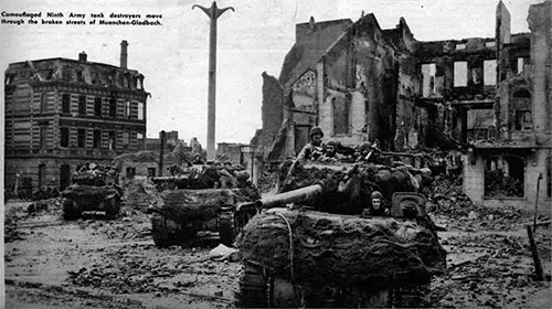 Camouflaged Ninth Army Tank Destroyers move through the broken streets of Muenchen-Gladbach