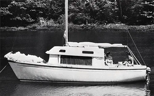 Relaxing on the New 1971 O'Day 23 Sailboat Anchored off the Coastline. Manufactured by O'Day, A Bangor Punta Company.