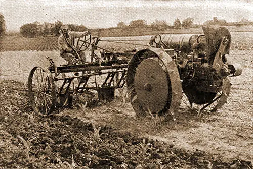 Farmer Is Using an All-around Tractor with a Cultivator.